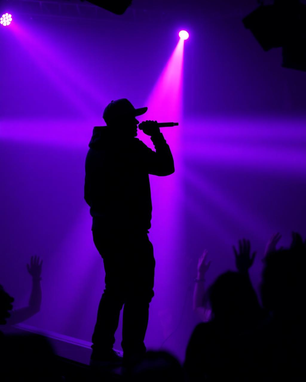 MC hyping the crowd under purple stage lights